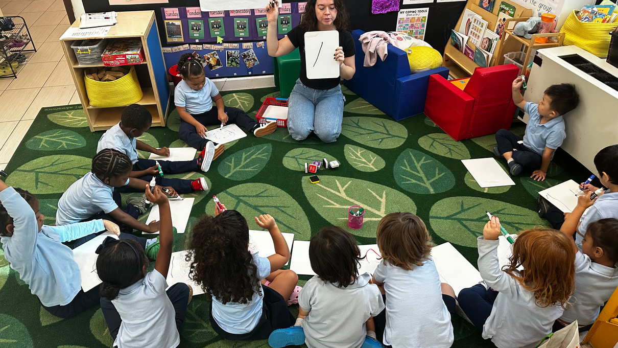 Teacher leading a hands-on learning activity with children at Two By Two Childcare Academy