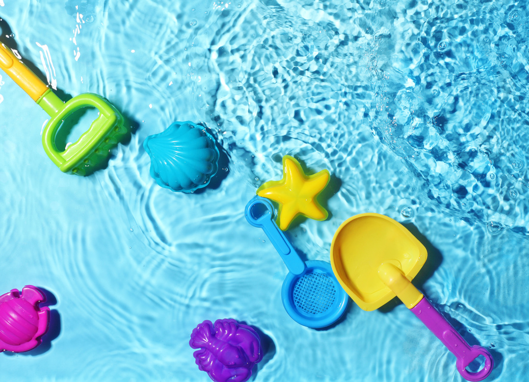Colorful water toys and scoops in a water table for summer sensory play