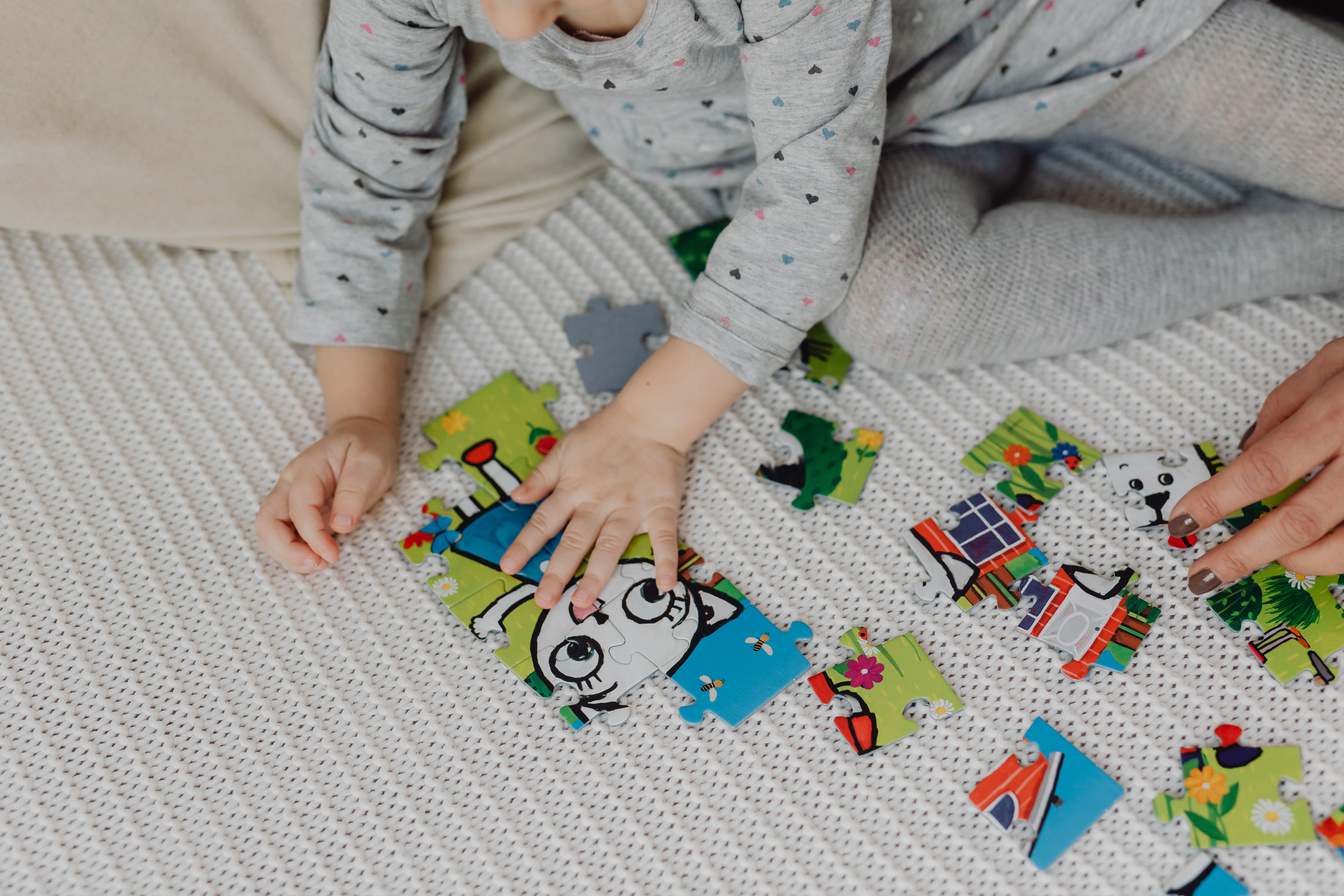 Child working on a puzzle, developing problem-solving and fine motor skills